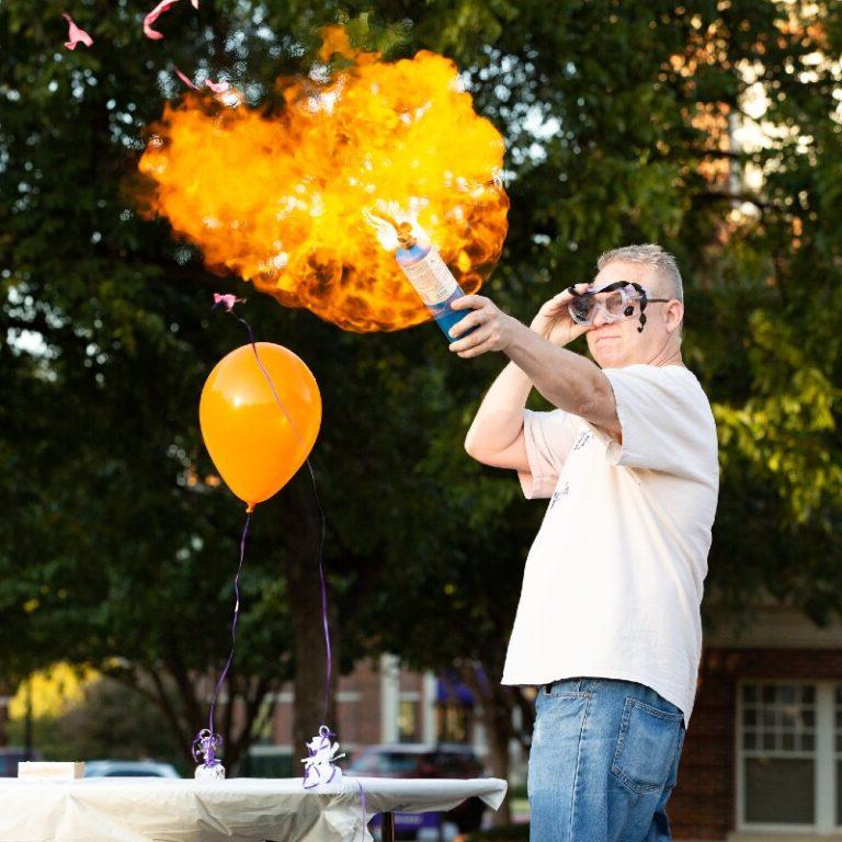 A chemistry professors explodes a balloon in flames.
